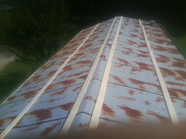 Rusted metal roof panels with new wood purlins before replacement — Storm Damage Roof Repair in Fred by Roofing Brothers